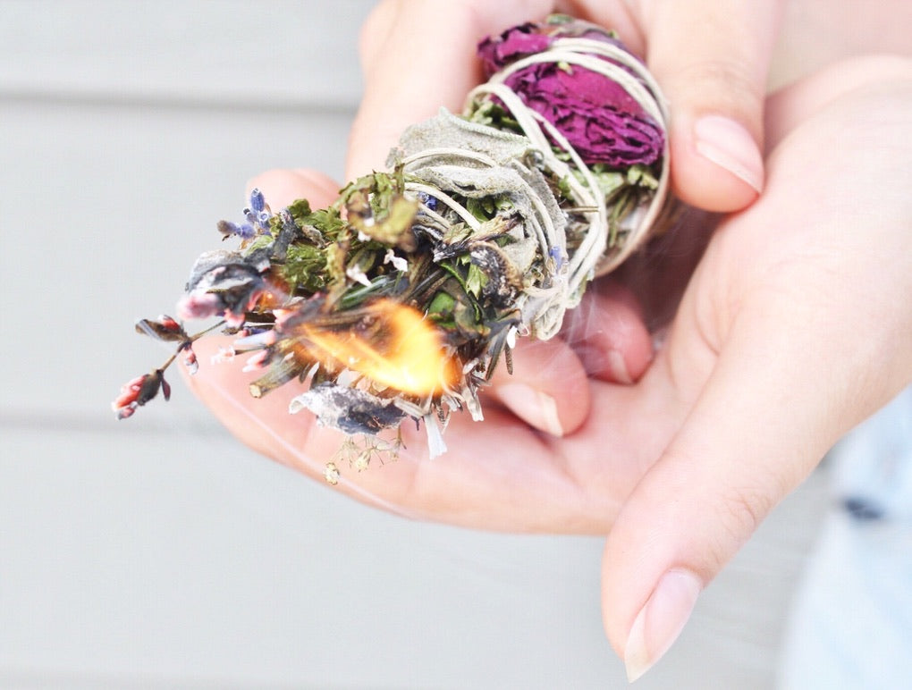 smudge stick smoke wand with mugwort and roses burning